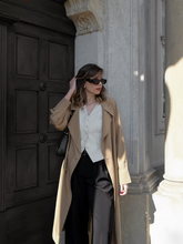 a lady wears a trench coat with black suit pants